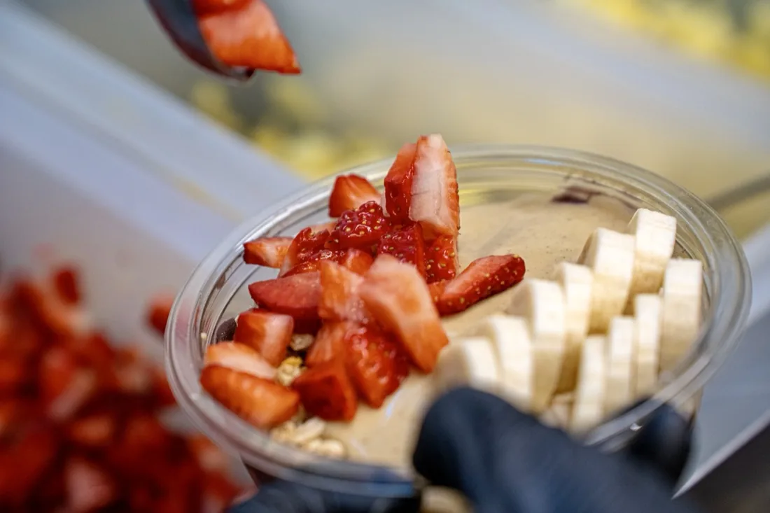 Preparando un acai bowl con fresa y plátano recién cortados