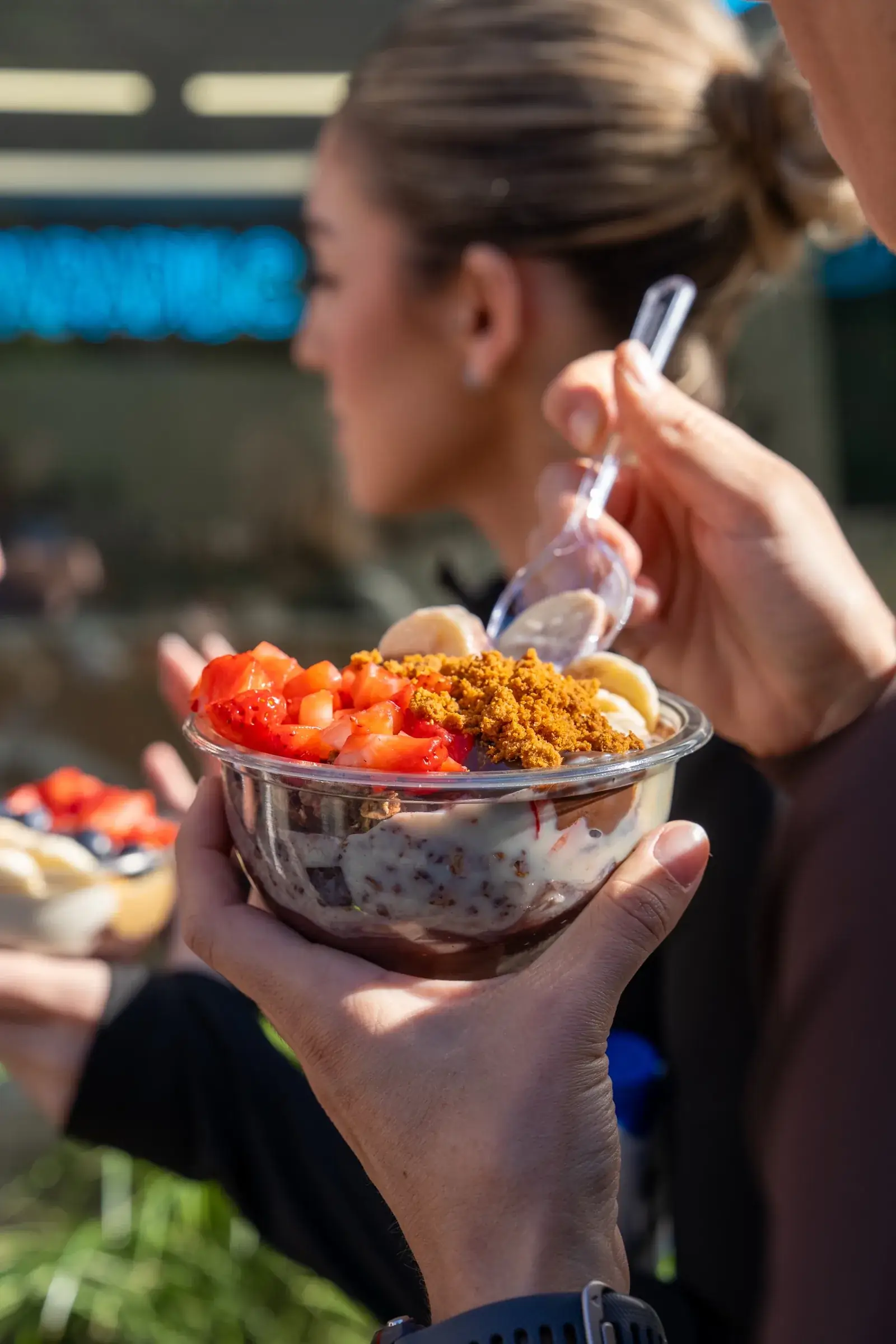 Clienta comiendo un bowl de açaí al sol